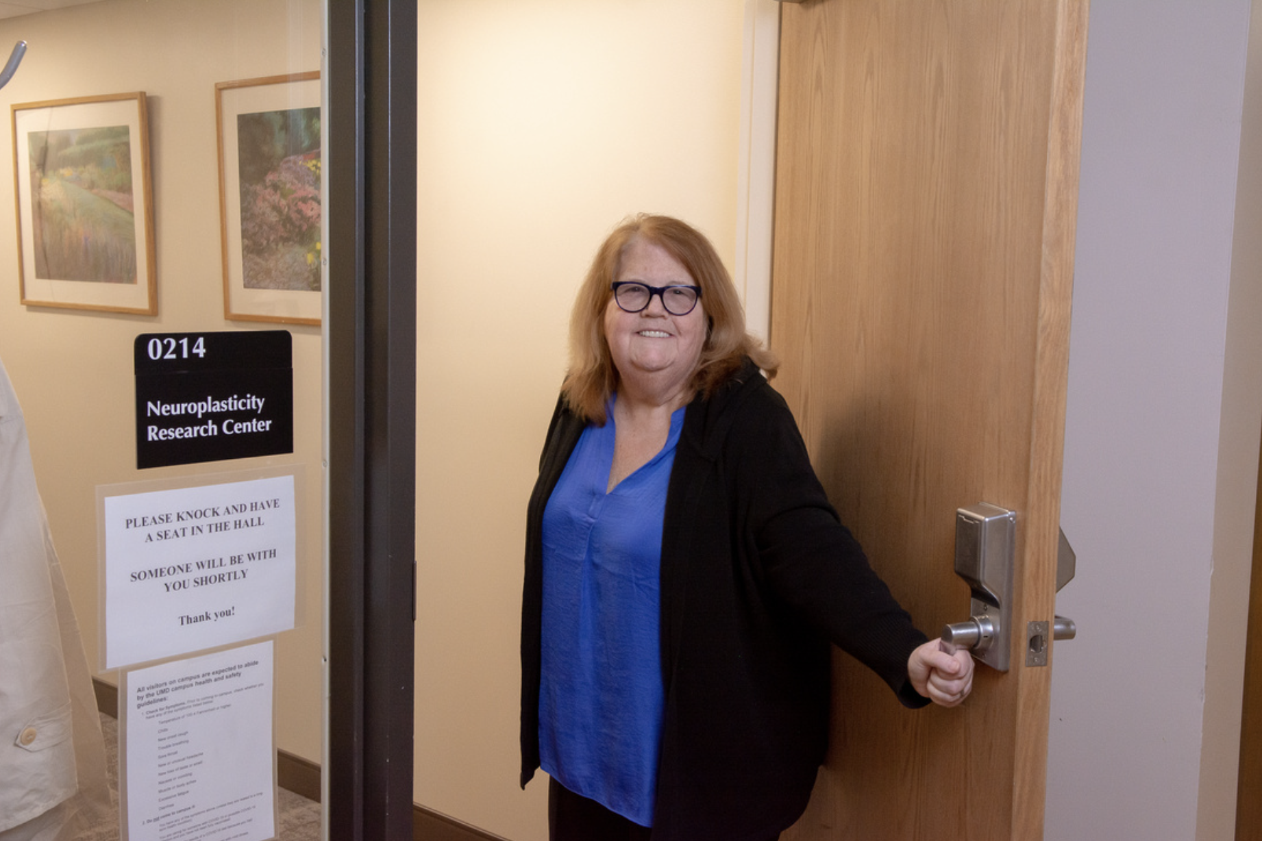 Woman standing next to an open door